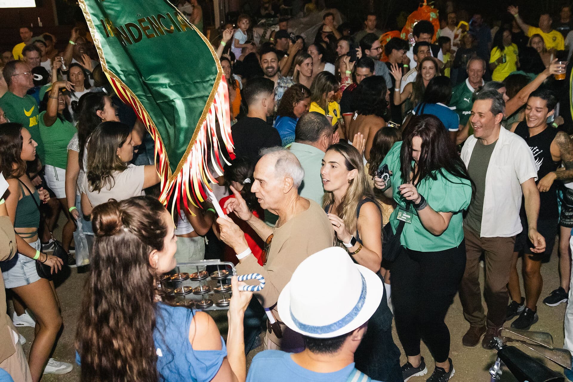 The crowd waving a Brazilian flag at night at Brazil Day ATX