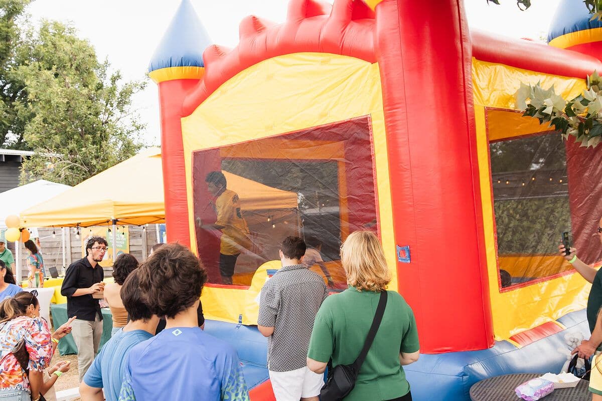 Kids lining up at the bounce house in the kids zone