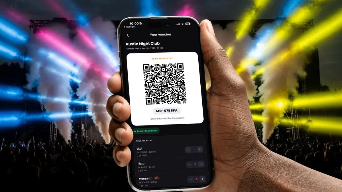 A food and drink voucher with a QR code on a phone at a concert